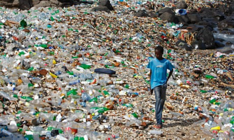 A person walking through the mountains of discarded plastic bottles...